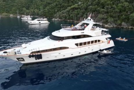 M/Y Friendship at anchor off a wooded coast
